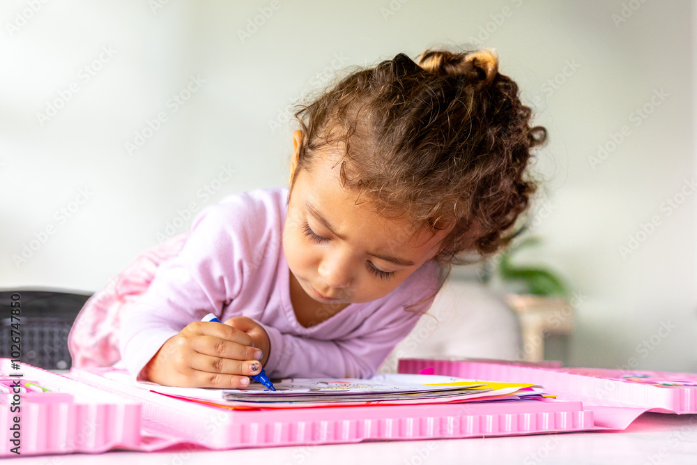 Young girl focused on coloring with her art set, enhancing creativity and fine motor skills at home