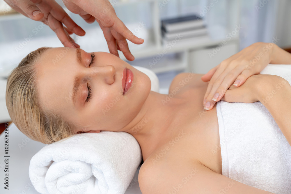 Fototapeta premium Caucasian woman enjoying relaxing anti-stress head massage and pampering facial beauty skin recreation leisure in dayspa modern light ambient at luxury resort or hotel spa salon. Quiescent
