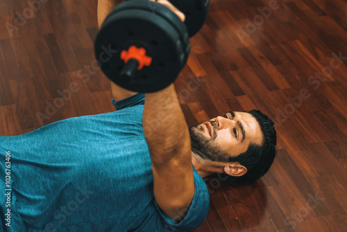 Athletic body and active sporty man lifting dumbbell weight for effective targeting muscle gain at gaiety home as concept of healthy fit body home workout lifestyle. photo