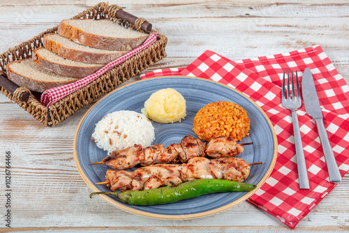 Grilled chicken on bamboo skewers. Chicken garbage skewer grill. Shish tavuk, Chicken shish kebab with french fries on platter. photo