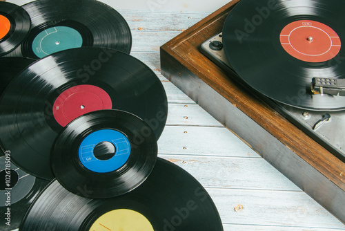 Old record player next to several vinyl records