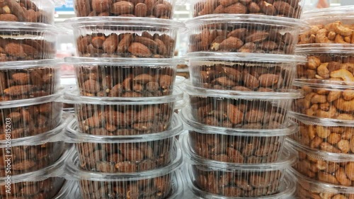 Different types of nuts in transparent plastic boxes on shelf in supermarket. Cashews, hazelnuts, almonds, peanuts in closeup package. Healthy foods for vegans and vegetarians. Snacks at grocery store