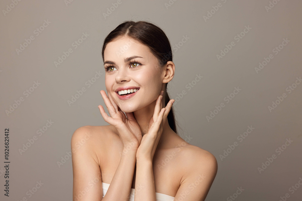 Beautiful young woman with clean skin and white towel posing on gray background Beautiful young woman with clean skin and white towel posing on gray background