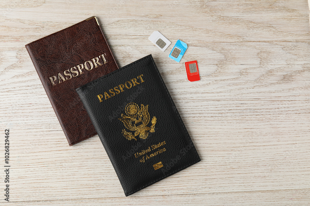 Passports and SIM cards on wooden table, flat lay Passports and SIM cards on wooden table, flat lay