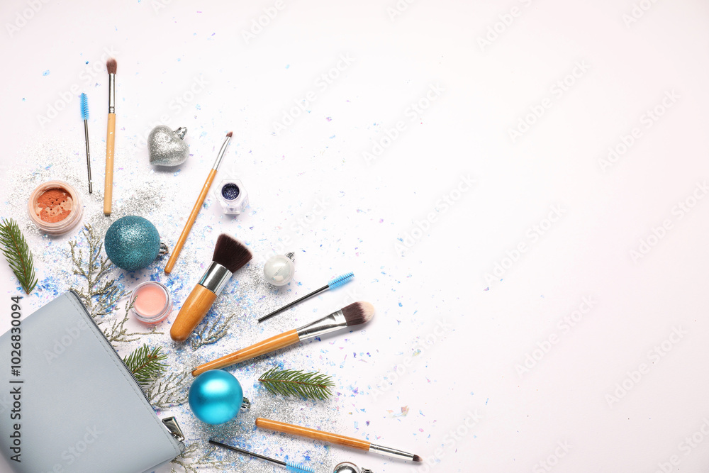 Fototapeta premium Cosmetic bag, makeup brushes, decorative cosmetics and Christmas decor on white background, flat lay. Space for text