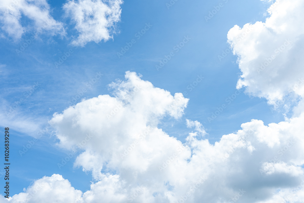Fluffy white clouds drift across a bright blue sky, casting soft shadows on the Earth Fluffy white clouds drift across a bright blue sky, casting soft shadows on the Earth