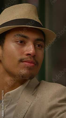 An Elegant Man Dressed in a Stylish Hat and WellFitted Suit Exuding Charm and Class photo