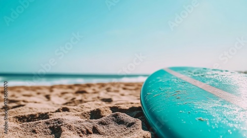 Serene Coastal Escape: Turquoise Surfboard on Sandy Beach photo