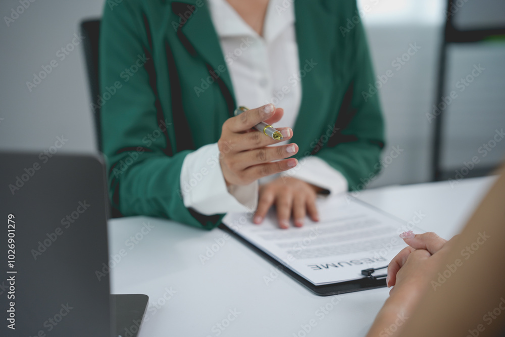 Human resources manager is holding a pen while interviewing a candidate for a job position Human resources manager is holding a pen while interviewing a candidate for a job position