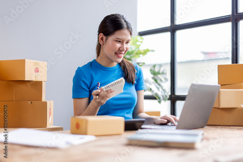 Startup small business entrepreneur SME, asian woman receive order on laptop. Success young Asian small business owner at home, online sell marketing delivery, SME e-commerce telemarketing concept 