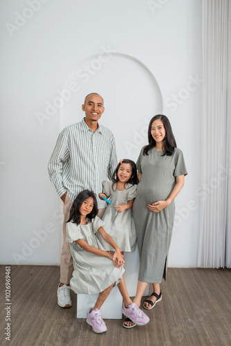 A family is happily posing together for a picture in a welldecorated room, capturing a memorable moment for their memories photo