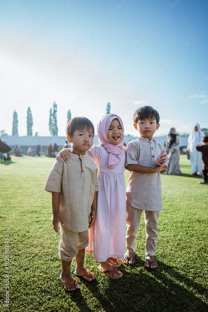 Three joyful children in colorful traditional clothes are enjoying a sunny day outdoors Three joyful children in colorful traditional clothes are enjoying a sunny day outdoors