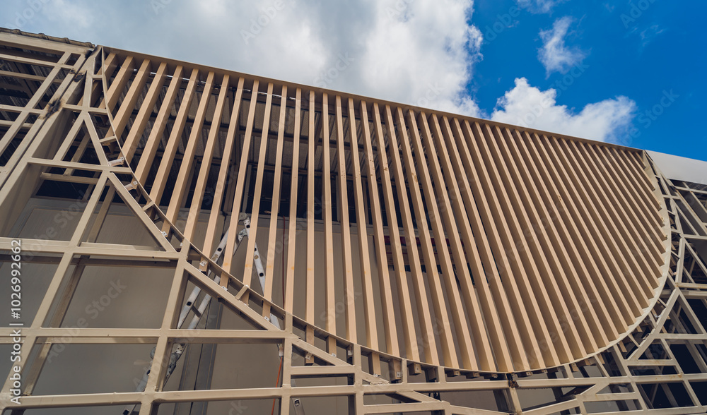 A structure featuring wooden slats on construction site contributing to its architectural style A structure featuring wooden slats on construction site contributing to its architectural style