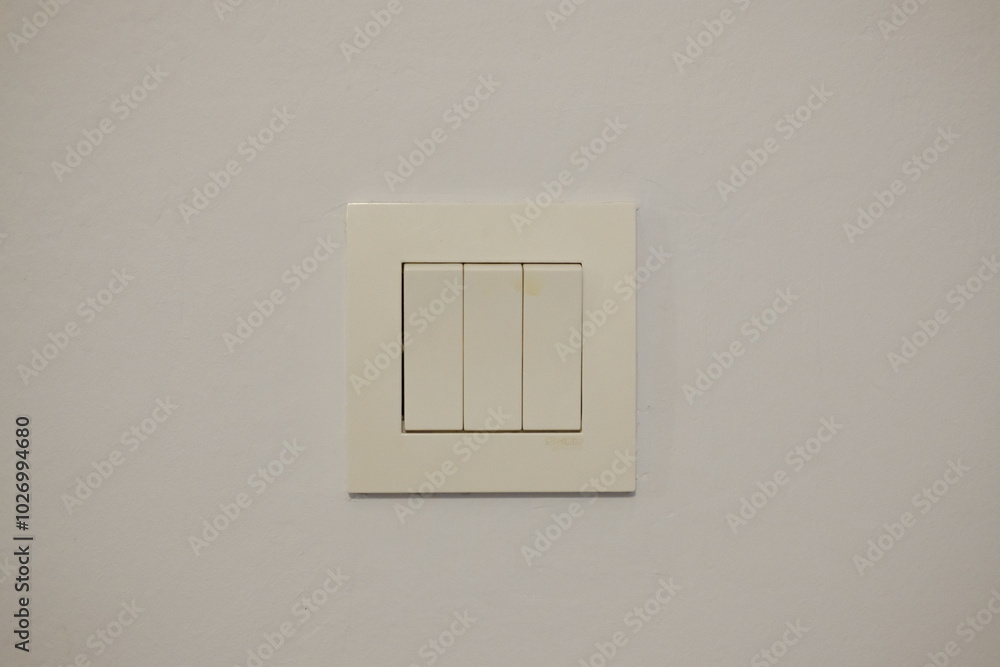 A plain light switch on a white wall. A plain light switch on a white wall.