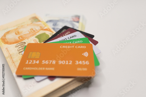 Orange credit card placed on a stack of Singapore dollar banknotes, symbolizing modern financial transactions, cashless payments, and digital banking . photo