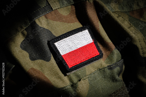 White and red flag of Polish on a camo military uniform