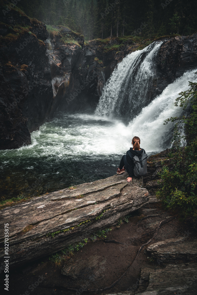 Girl looking at a waterfall in norway Girl looking at a waterfall in norway