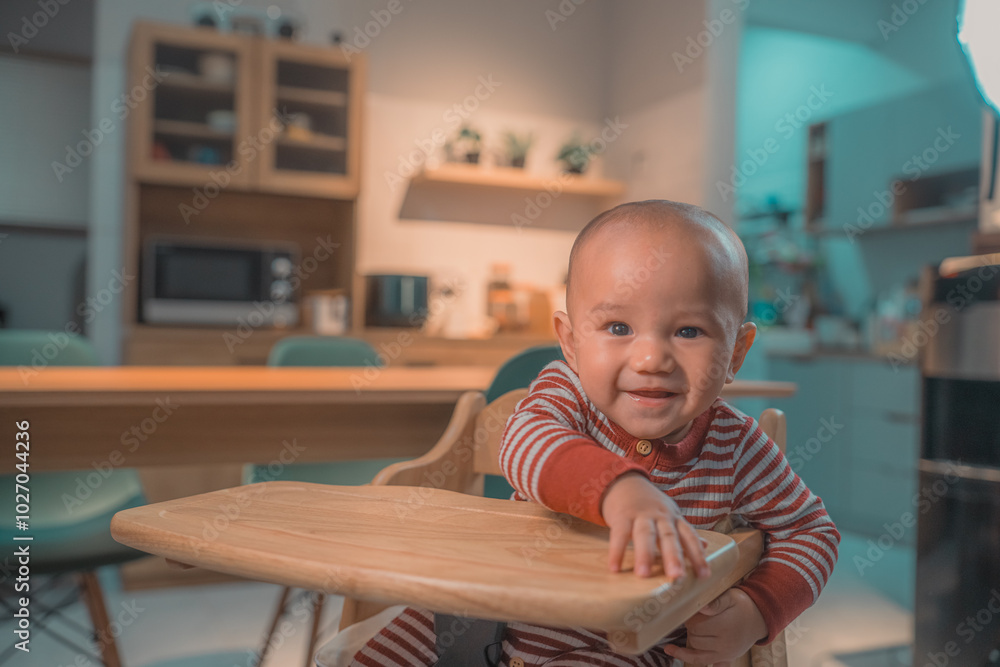 A cheerful and happy baby joyfully enjoying their time in a bright modern kitchen setting A cheerful and happy baby joyfully enjoying their time in a bright modern kitchen setting