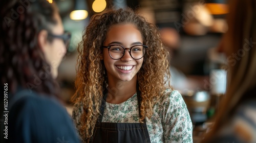 A smiling young woman with special needs is working at Starbucks, wearing an apron and glasses while serving customers in the store.