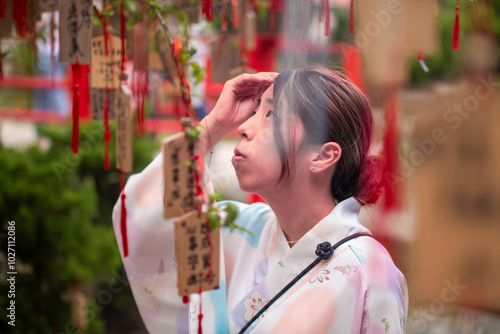 A Kimono-Clad Woman Gazes Upward at the Ema on the Wish Tree Beneath the Torii Gate, Capturing a Moment of Dream and Aspiration
