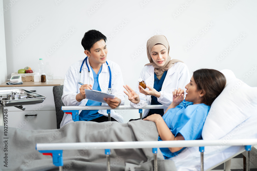 Fototapeta premium Hospital Ward Male and Male Professional Asian Doctors Talk with a Patient, Give Health Care Advice, Recommend Treatment Plan