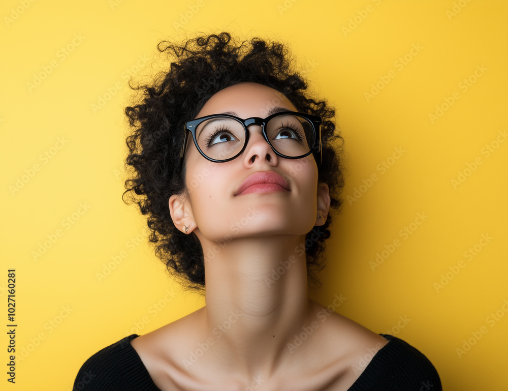 A person wearing glasses stands on a bright yellow background, ready for a photo shoot or a presentation A person wearing glasses stands on a bright yellow background, ready for a photo shoot or a presentation