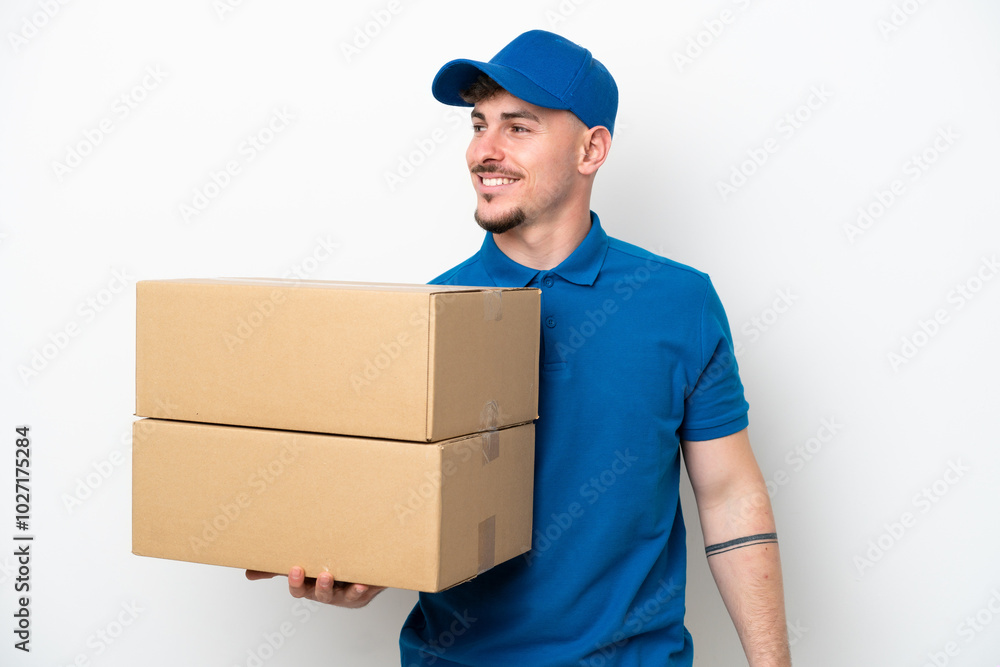 Delivery caucasian man isolated on white background looking to the side and smiling Delivery caucasian man isolated on white background looking to the side and smiling