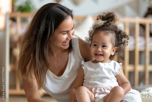 A Happy caucasian mother sits on floor in nursery and