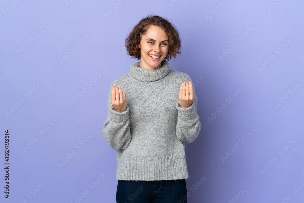 Fototapeta premium Young English woman isolated on purple background making money gesture