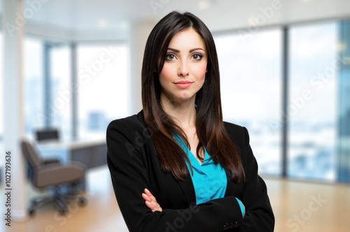 Confident businesswoman standing with arms crossed in office