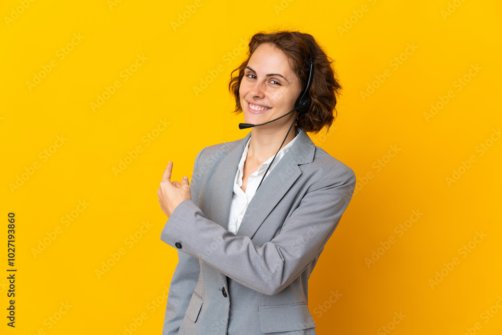 Young English woman isolated on yellow background pointing back Young English woman isolated on yellow background pointing back
