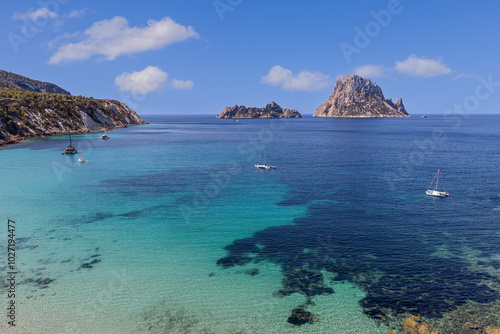 Fotografija Overlooking Cala d Hort in Ibiza, this image captures the pristine emerald water