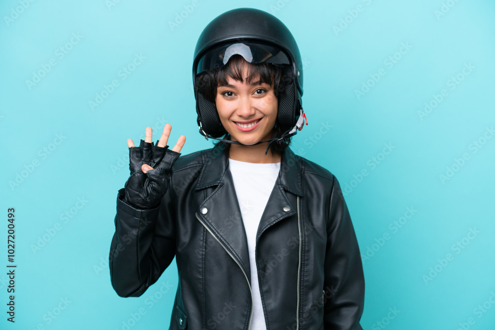 Young Argentinian woman with a motorcycle helmet isolated on blue background happy and counting four with fingers Young Argentinian woman with a motorcycle helmet isolated on blue background happy and counting four with fingers