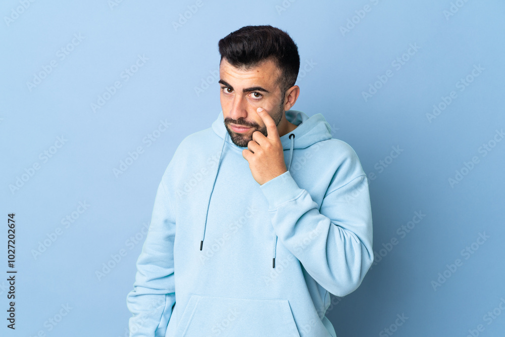 Caucasian man over isolated blue background showing something Caucasian man over isolated blue background showing something