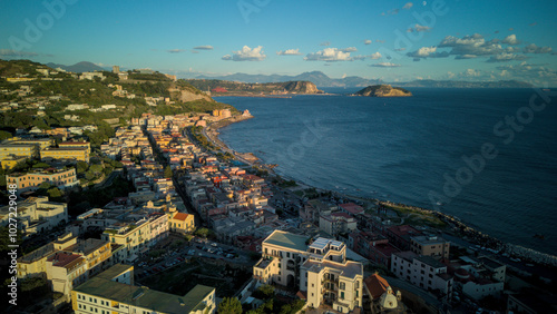 A stunning aerial shot of Pozzuoli, highlighting its scenic coastline and vibrant harbor.The drone captures the ancient Roman ruins, the calm sea, and the natural beauty surrounding the historic city. photo