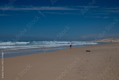 un homme court sur la plage au loin