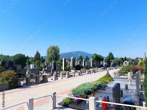 cemetery in Maribor. Grave monuments and a walkway. Blue sky