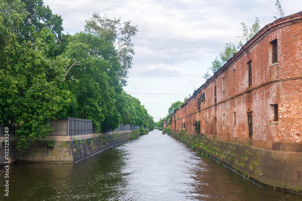 Obvodny Canal in Kronstadt, view of old drainage canal with an abandoned warehouse building on the bank