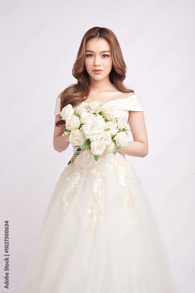 Beautiful young asian woman in wedding dress holding bouquet on white background, Beautiful young asian woman in wedding dress holding bouquet on white background,