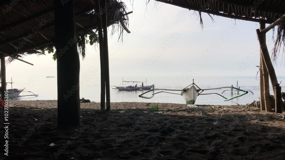 Beautiful view of a boat anchored by the sea viewed from a bamboo cottage on a bright and sunny day Beautiful view of a boat anchored by the sea viewed from a bamboo cottage on a bright and sunny day