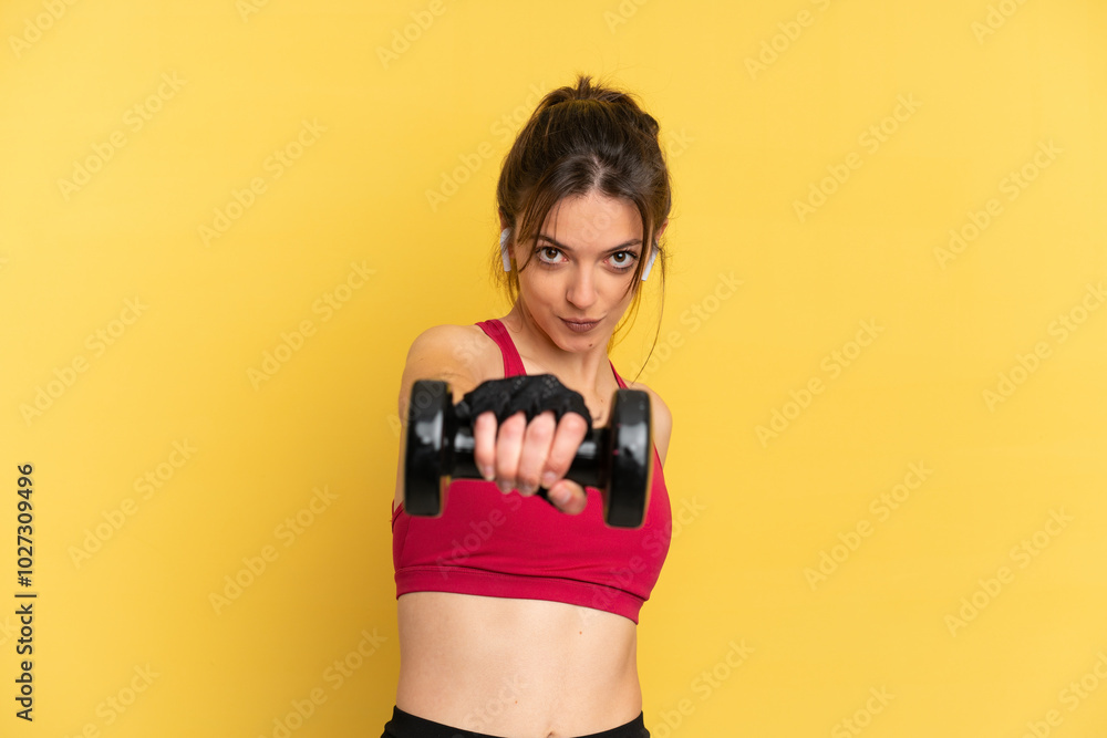 Naklejka premium Young caucasian woman isolated on blue background making weightlifting