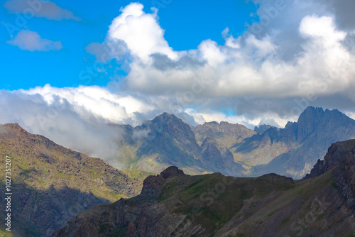 Peak of the mountains and partly cloudy sky. Landscape of the mountains