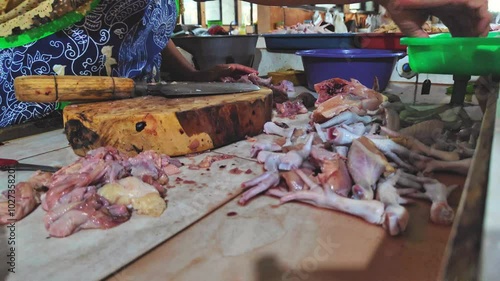 Chicken traders cutting fresh chicken at a traditional market photo