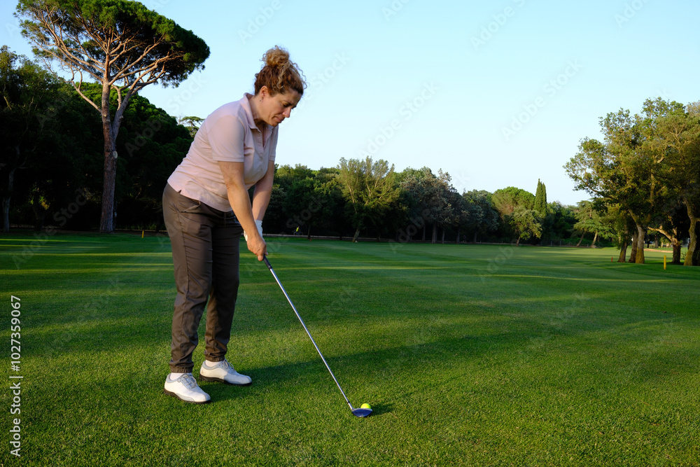 Fototapeta premium woman playing golf on the green fairway course