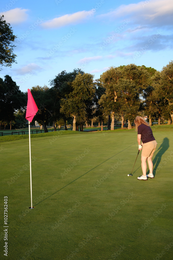 Fototapeta premium woman playing golf on the green fairway course