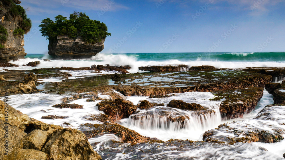 The beauty of Karang Bokor Beach, Sawarna, Banten. Large rock decorated with trees in the middle of the sea are the main attraction of this view with the crashing waves add to the dynamic impression. The beauty of Karang Bokor Beach, Sawarna, Banten. Large rock decorated with trees in the middle of the sea are the main attraction of this view with the crashing waves add to the dynamic impression.