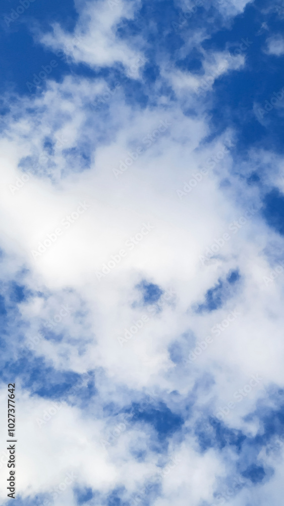 Fototapeta premium Lots of White cumulus clouds on blue sky. Colorful Beautiful vertical natural Mostly cloudy background.