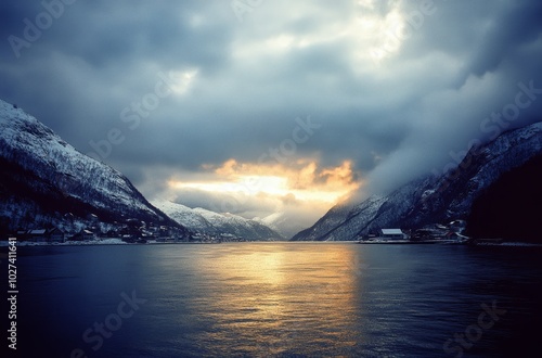 The sun sets behind mountains, casting a warm glow over the calm waters of a Norwegian fjord on a chilly winter evening