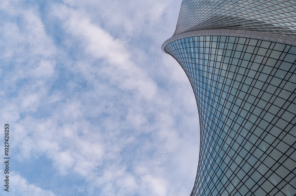Angled view of modern skyscrapers in business district against blue sky. Looking Up high-rise office buildings.