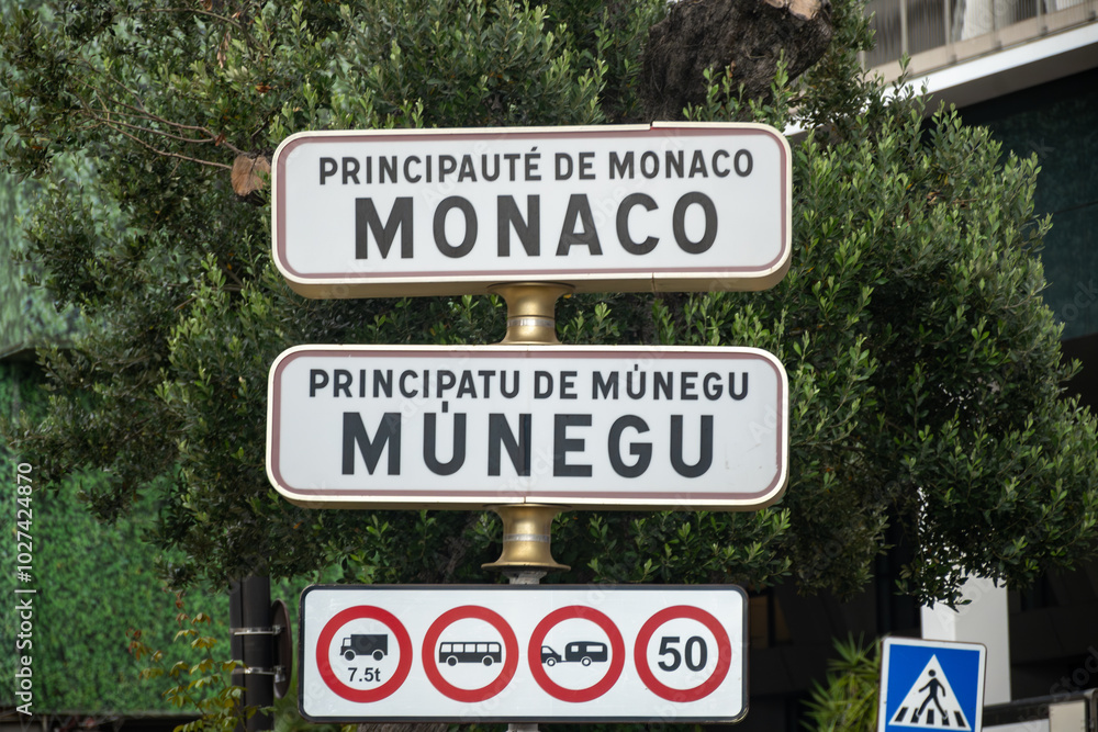 Driving car on French Riviera, road signes with directions to Monaco, english translation of board: border of Monaco principality, traffic and parking problems Driving car on French Riviera, road signes with directions to Monaco, english translation of board: border of Monaco principality, traffic and parking problems